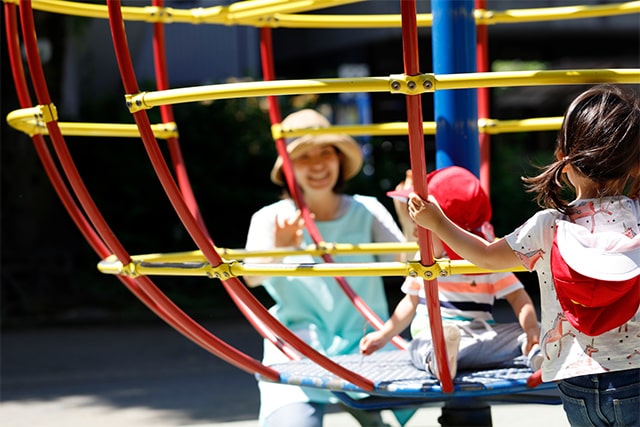 写真:遊具で遊ぶ園児と保育士
